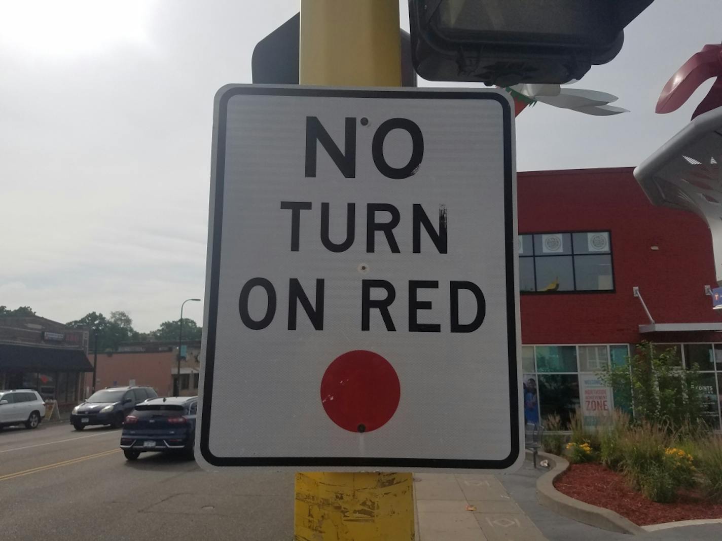 This "No Turn on Red" with a red dot at the bottom at the intersection of Penn Avenue and West Broadway in north Minneapolis is the new standard for the traffic signs, but older versions remain at many intersections throughout the city.