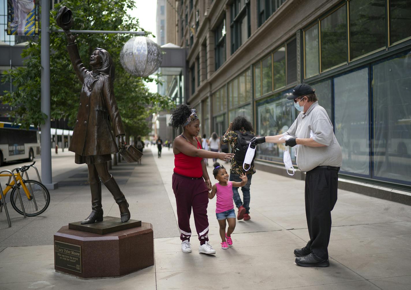 Porcha Lacey, with her daughter, Lyric, took Metro Transit's Tony Dodge up on his offer of a free face mask at the corner of 7th & Nicollet Thursday afternoon. ] JEFF WHEELER • Jeff.Wheeler@startribune.com Metro Transit workers distributed free masks on downtown street corners Thursday afternoon, June 25, 2020 in Minneapolis.