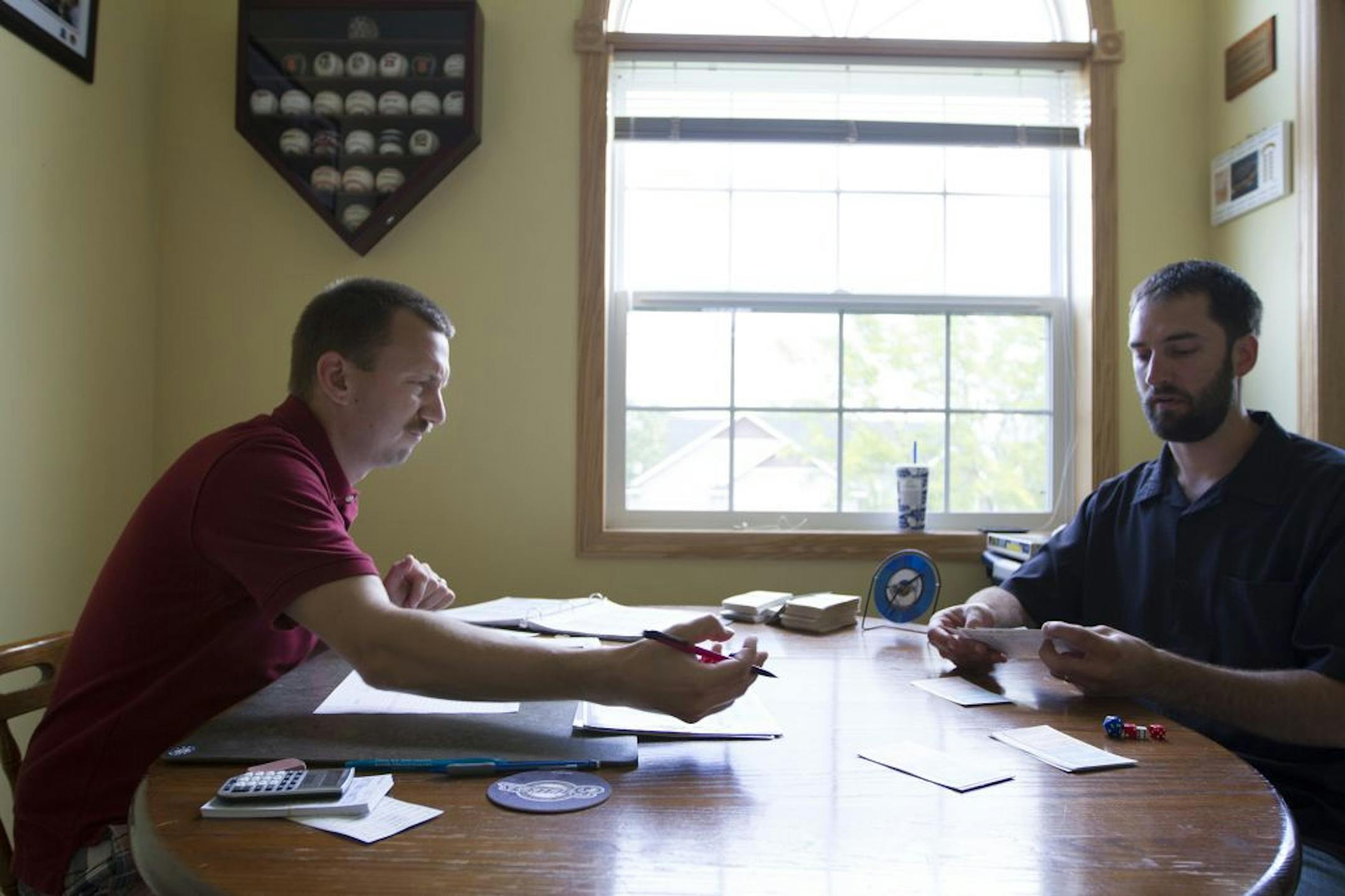 Brett Carow, left, and Sam Hennemann play a game of Srat-O-Matic on Tuesday, May 29 at Carow's home in Farmington.