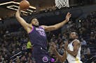 CORRECTS TO KEVIN DURANT, NOT DRAYMOND GREEN - Minnesota Timberwolves' Karl-Anthony Towns, left, lays up as Golden State Warriors' Kevin Durant watche