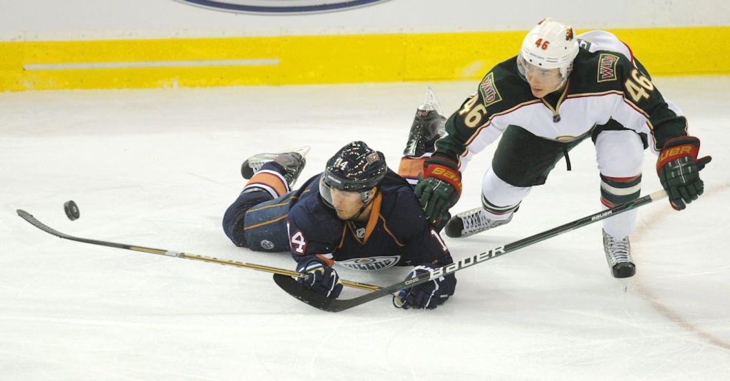 Jared Spurgeon, right, of the Wild kept his eye on the puck as the Edmonton Oilers' Jordan Eberle batted it around during an October meeting in Edmonton.