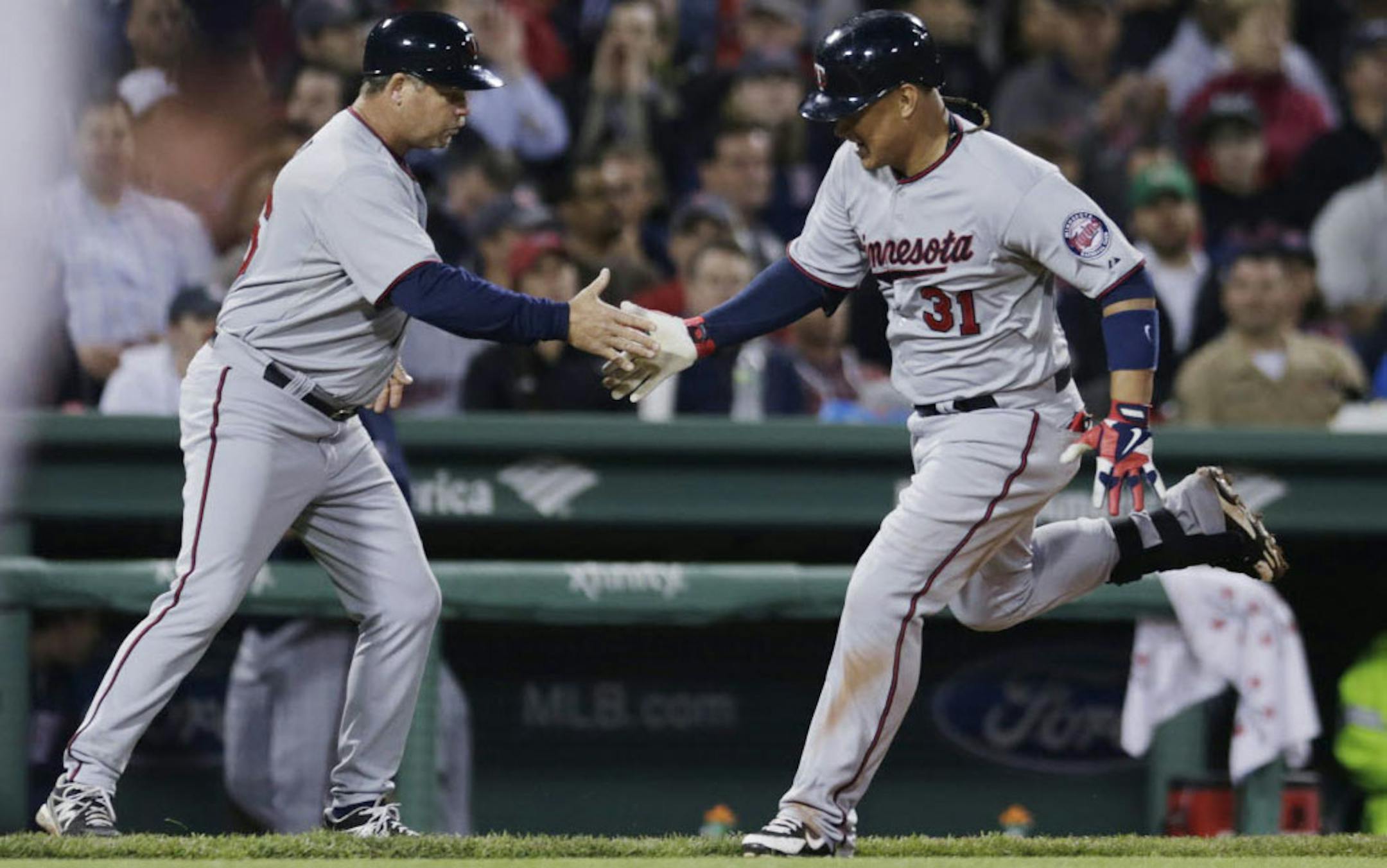 The Twins' Oswaldo Arcia was congratulated by third base coach Joe Vavra as he rounded the bases on a two-run homer during the sixth inning.