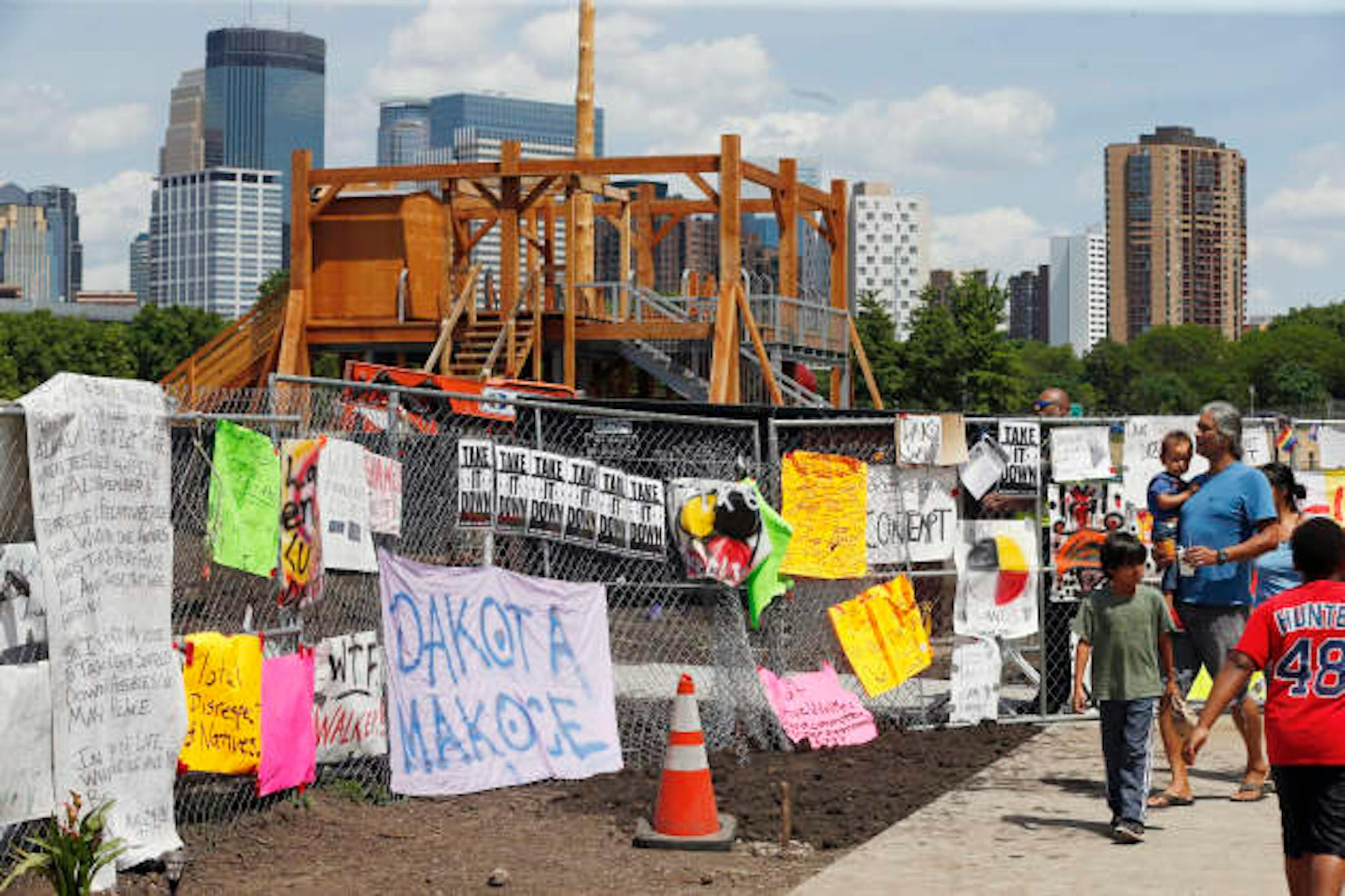 Pubic sentiment is displayed on fencing Friday, June 2, 2017 at the Walker Art Center in Minneapolis. where four-days of dismantling of the controversial sculpture "Scaffold", center, was to begin. Dismantling will be overseen by Dakota tribal elders. The Dakota people say "Scaffold", based in part of the design of the gallows used to execute 38 Dakota men in Mankato, Minn., in 1862, is not art and represents a painful history that Minnesotans have log ignored. (AP Photo/Jim Mone)