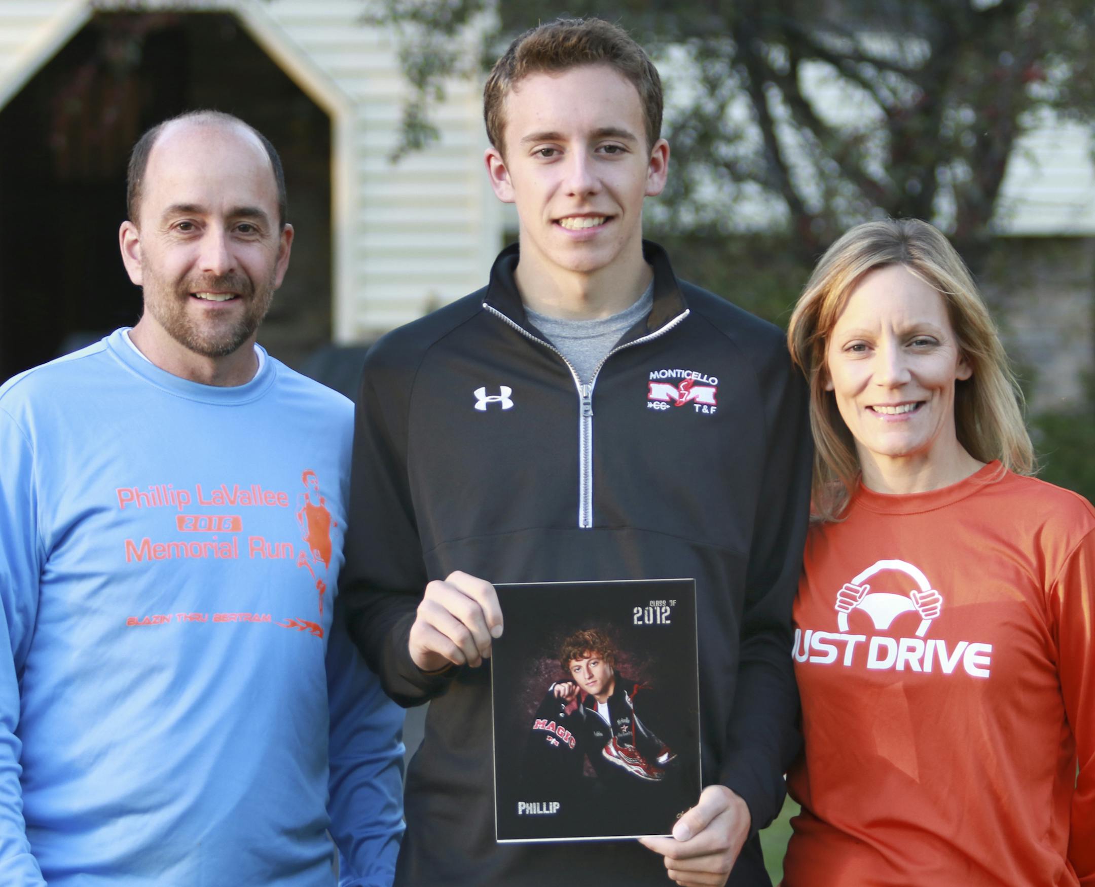 The LaVallee family, husband Greg, son Marcus and wife Amy with a photo of the LaVallee's oldest son Phillip. Phillip was hit by a distracted driver while on a run in August 2013.