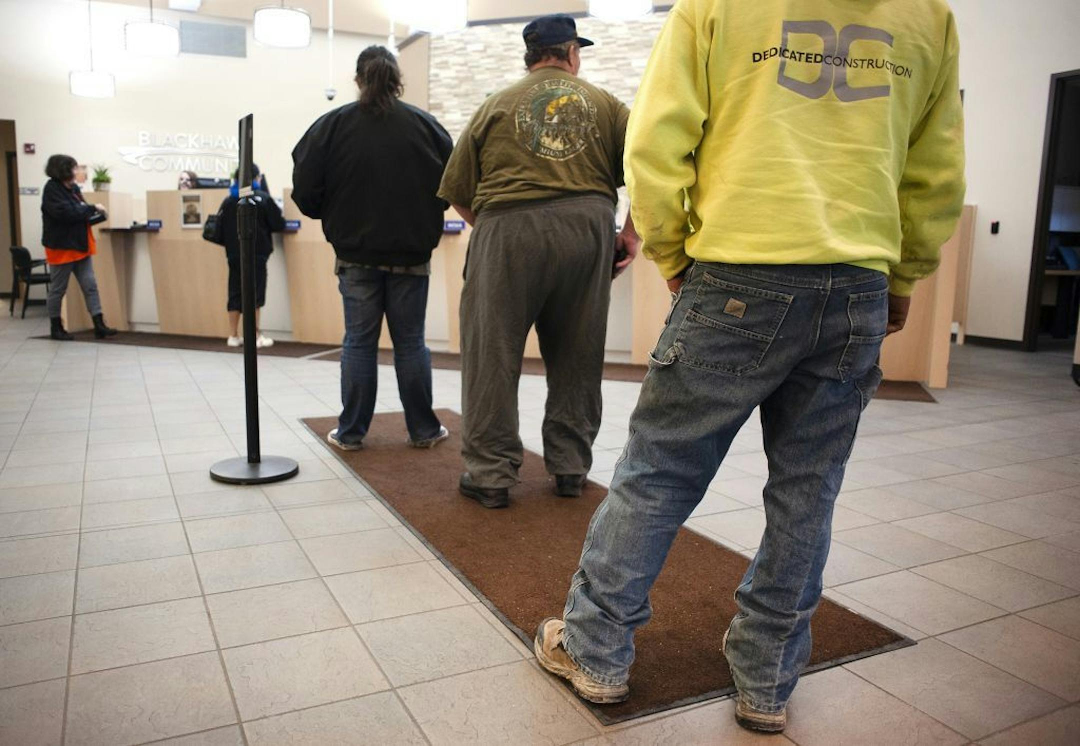 FILE - In this Nov. 16, 2018, file photo credit union members stand in line at Blackhawk Community Credit Union on East Milwaukee Street in Janesville, Wis. Credit unions, with their great savings and loan rates and excellent service, offer an alternative to traditional banks.