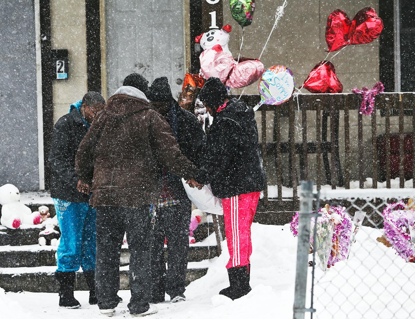 Minneapolis resident Martin Miller, in brown with back to camera, stopped by the charred duplex and led a small group in an impromptu prayer Saturday, Feb. 15, 2014, in Minneapolis, MN.]"Let's all hold hands and pray for this family right now," Miller told those gathered.](DAVID JOLES/STARTRIBUNE) djoles@startribune.com A day after a northside fire took the lives of five, including three children, a steady stream of vehicles with onlookers inside rolled slowly by the duplex, some snapping photos