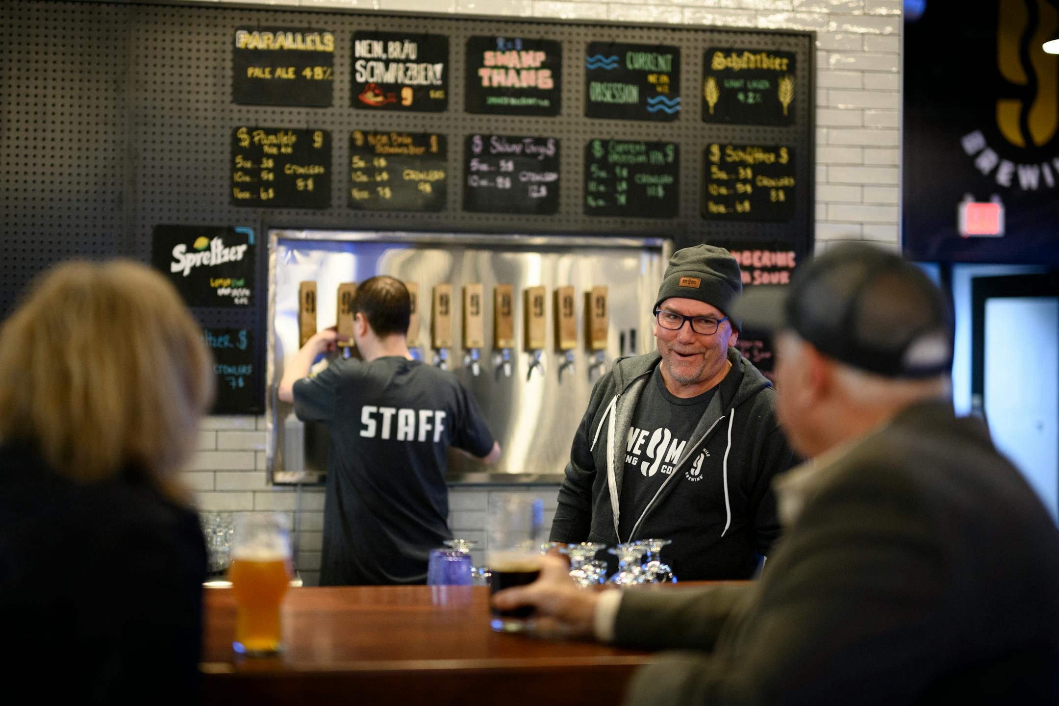 Nine Mile Brewing beertender Tim O'Harris spoke with patrons at the bar Wednesday, Feb. 9, 2022 at Nine Mile Brewing in Bloomington, Minn.