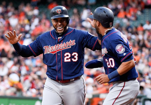 Nelson Cruz (23) and Eddie Rosario celebrated after scoring on C.J. Cron's RBI double against the Astros in Houston.
