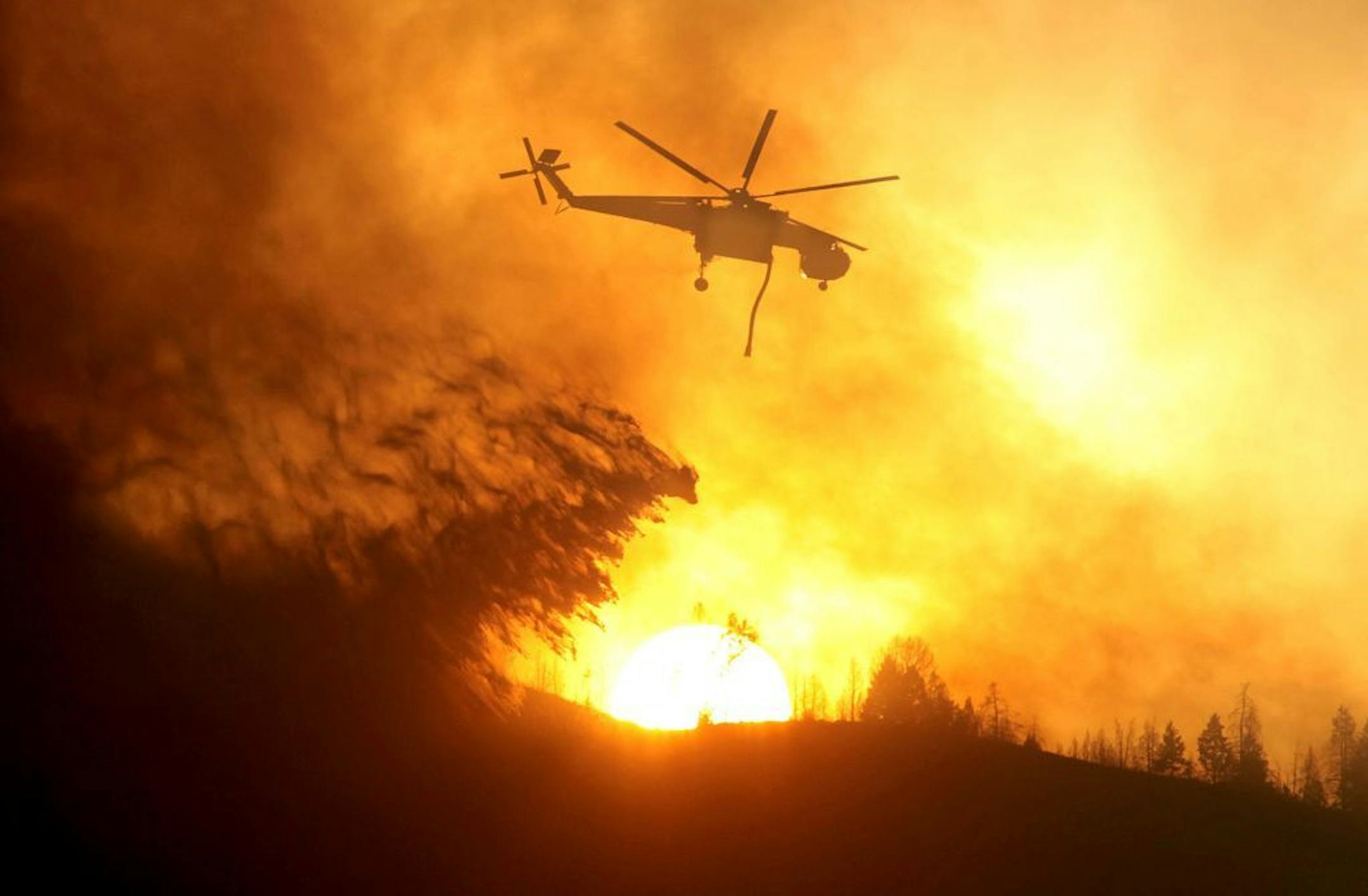 A helicopter makes a drop while battling the Beaver Creek Fire north of Hailey, Idaho.