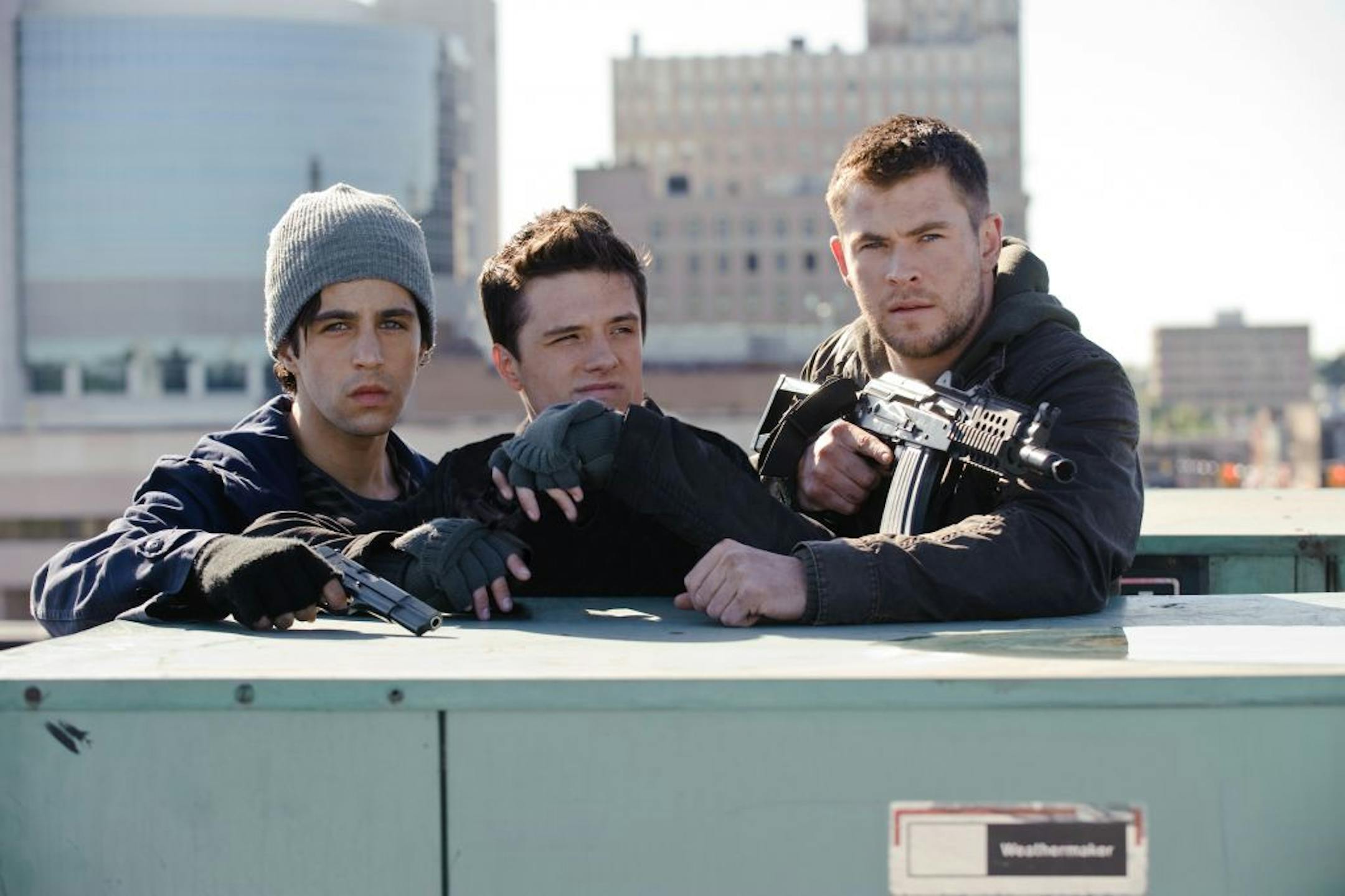This film image released by Film District shows Josh Peck , left, Josh Hutcherson, center, and Chris Hemsworth in a scene from "Red Dawn."