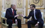 President Donald Trump and French President Emmanuel Macron gesture during their meeting inside the Elysee Palace in Paris Saturday Nov. 10, 2018.