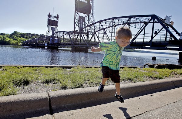 Ben Slagle, 2, and his mother Desiree Slagle took a stroll along the St. Croix River as the Minnesota Department of Transportation workers worked on t