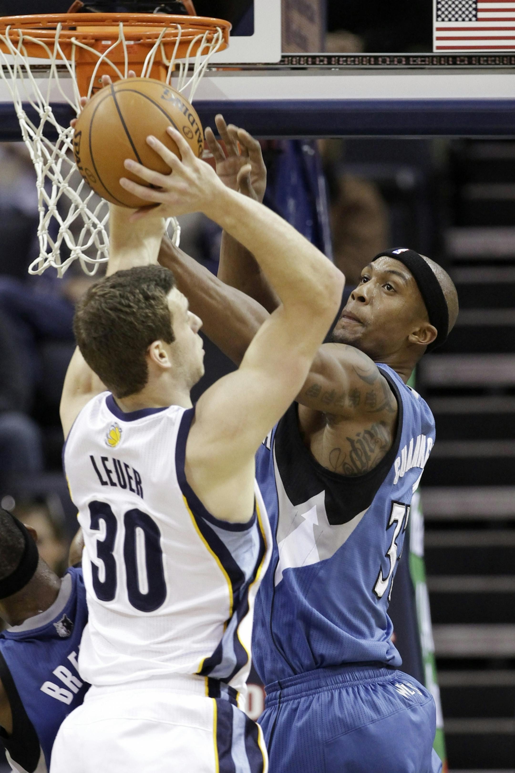 The Grizzlies' Jon Leuer (30), a former Orono High star, grabbed a rebound away from the Wolves' Dante Cunningham in the first half Sunday.
