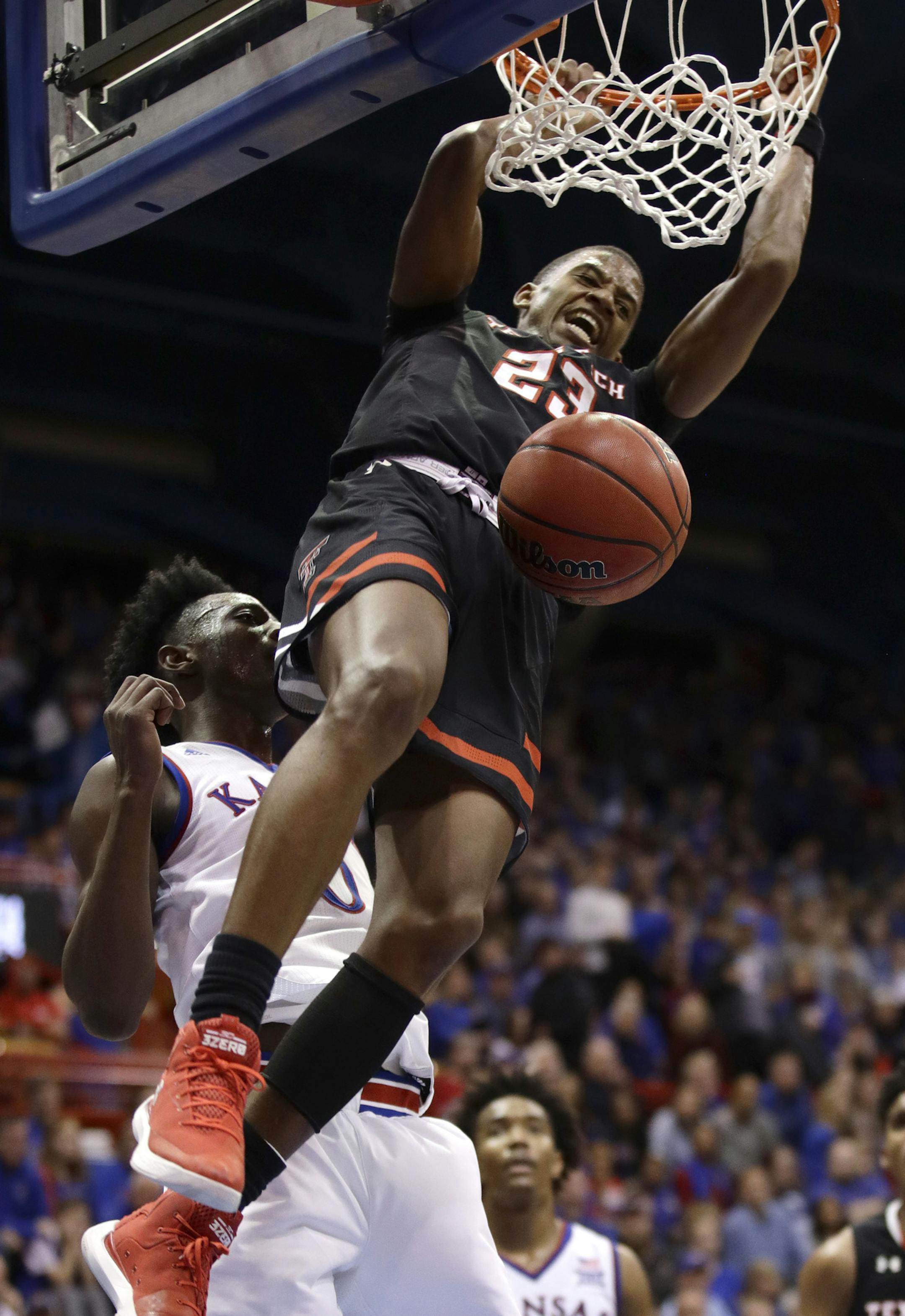 Texas Tech's Jarrett Culver (23) gets past Kansas' Marcus Garrett to dunk during the second half of an NCAA college basketball game Tuesday, Jan. 2, 2018, in Lawrence, Kan. Texas Tech won 85-73. (AP Photo/Charlie Riedel) ORG XMIT: KSCR114