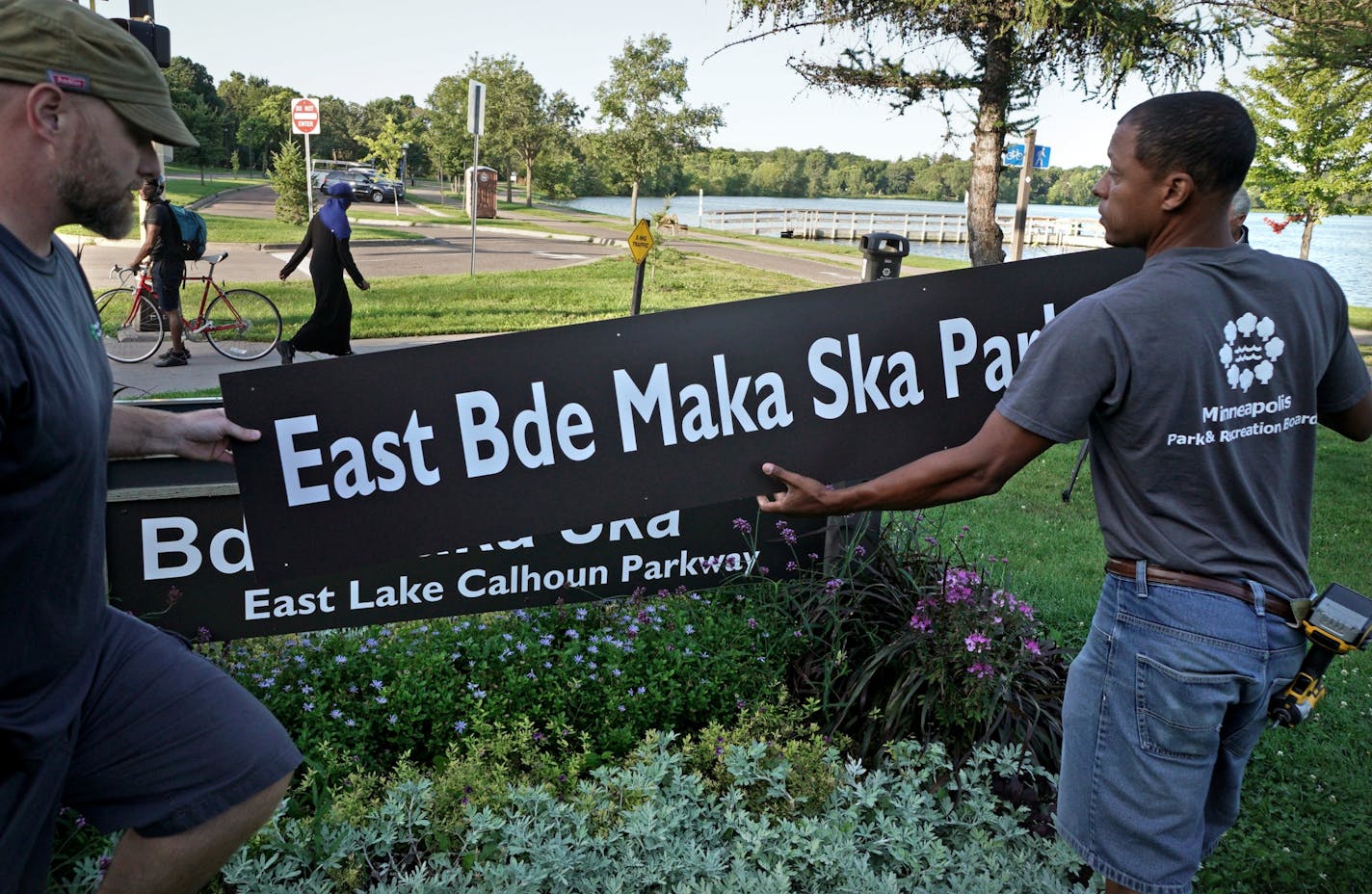 Minneapolis Park and Recreation Board (MPRB) workers install new placards changing East and West Lake Calhoun Parkways to East and West Bde Maka Ska Parkways.