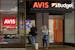 A couple stands in front of an Avis Budget rental car office, Friday, Oct. 14, 2022, in Boston. (AP Photo/Michael Dwyer)
