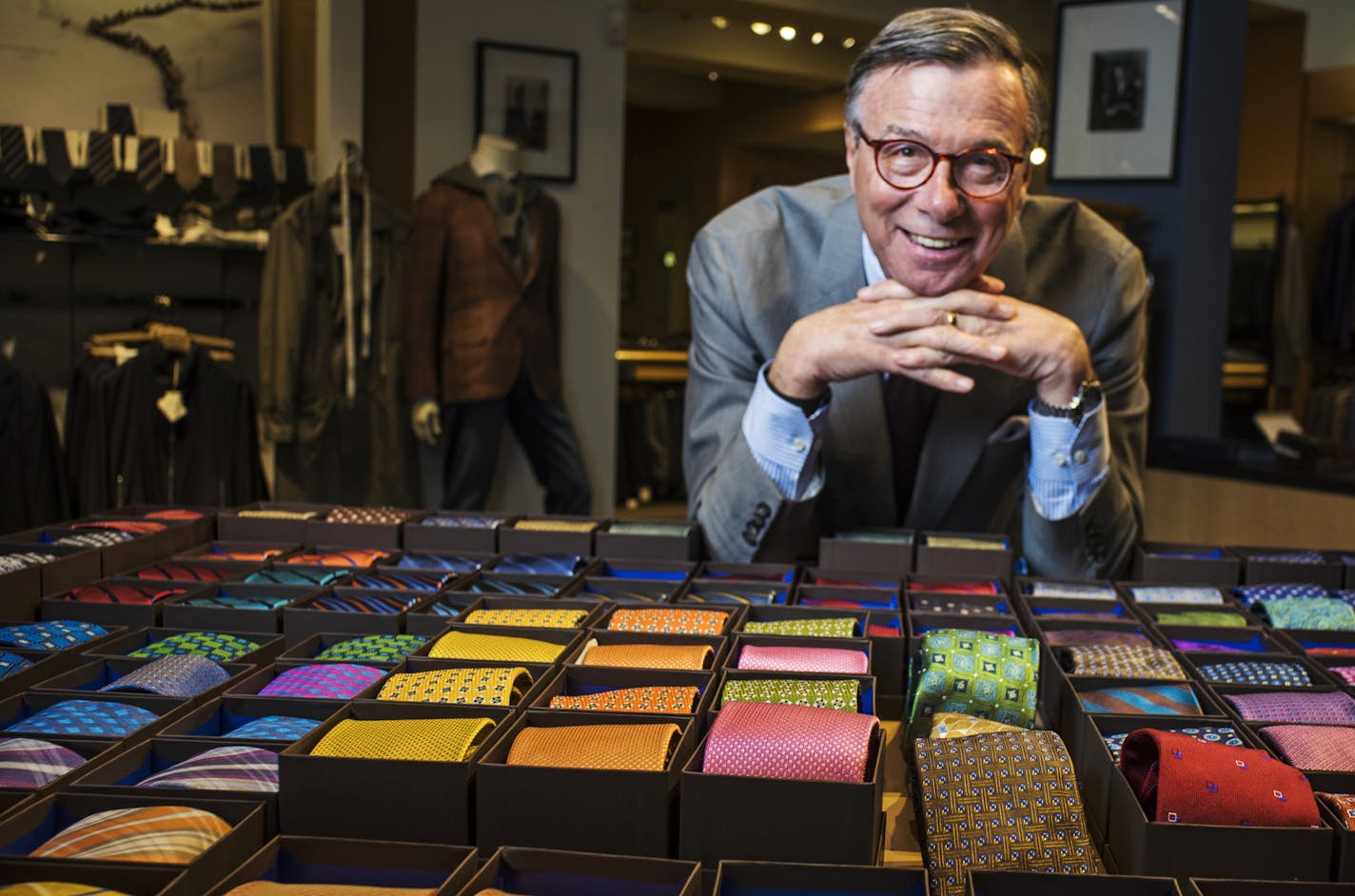 Bob White, leaning over a collection of ties at his Hubert White clothing store, is the grandson of the business&#x2019; founder and namesake.