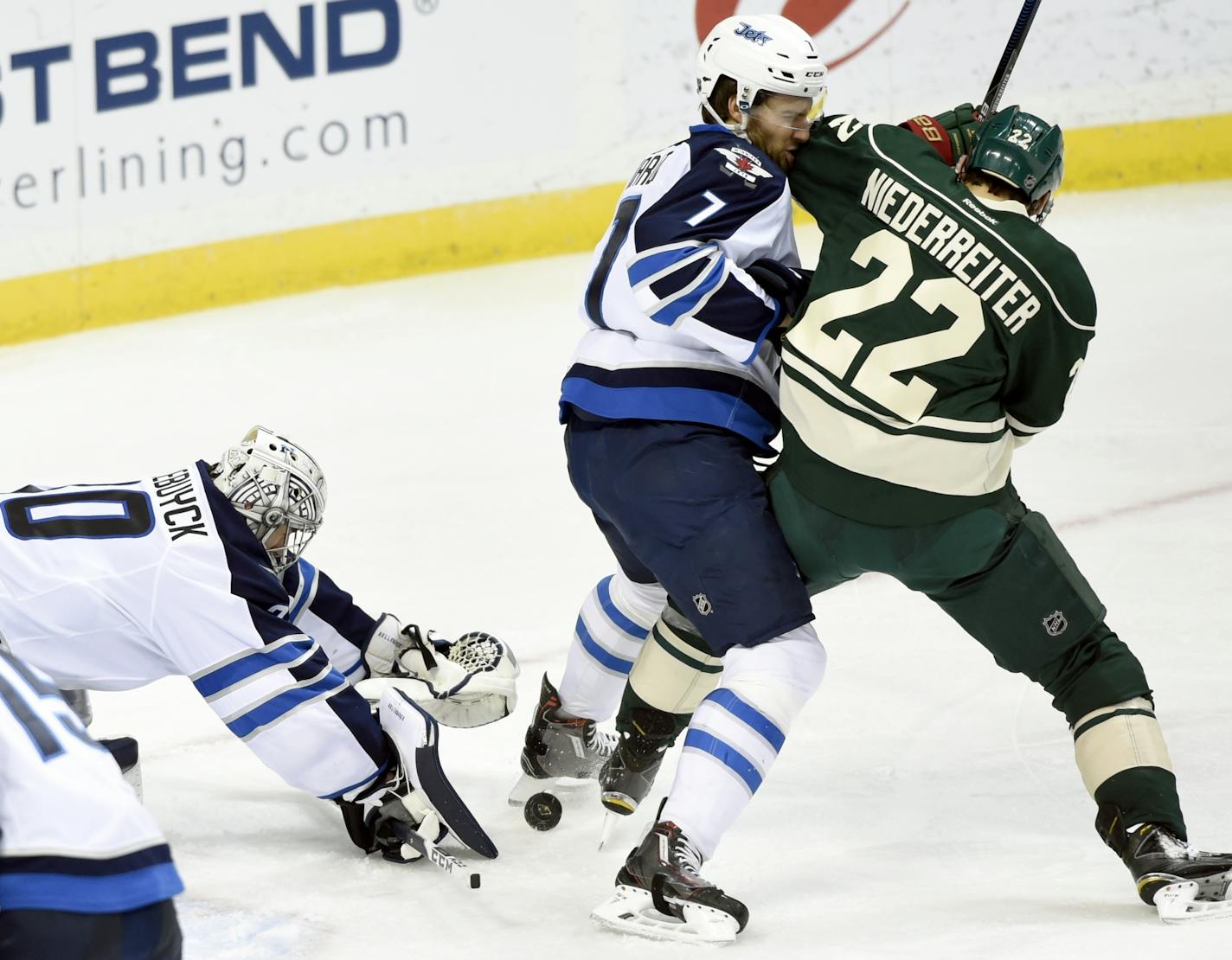 Winnipeg Jets goalie Connor Hellebuyck (30) covers up the puck as defenseman Ben Chiarot (7) pushes Minnesota Wild right wing Nino Niederreiter (22), of Switzerland, away during the third period of an NHL hockey game Friday, Jan. 15, 2016, in St. Paul, Minn. The Jets won 1-0.