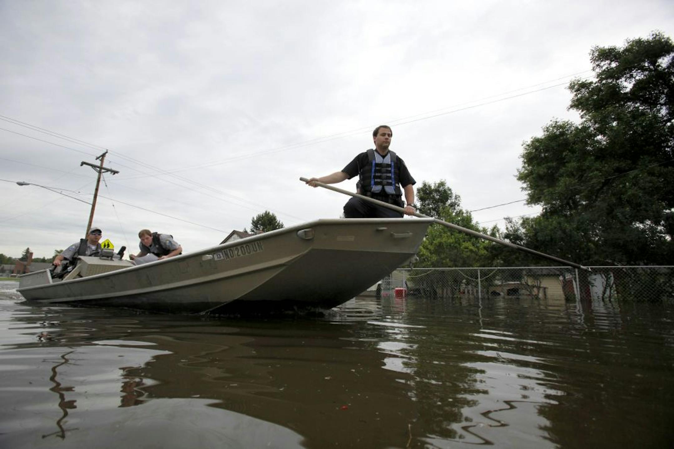 Minot Police officers navigate via boat responding to 911 calls coming from homes in the evacuated Souris River flood zone Friday, June 24, 2011 in Minot, N.D. The river is expected to break a more than century-old record on Friday and go 6 or 7 feet higher by this weekend.