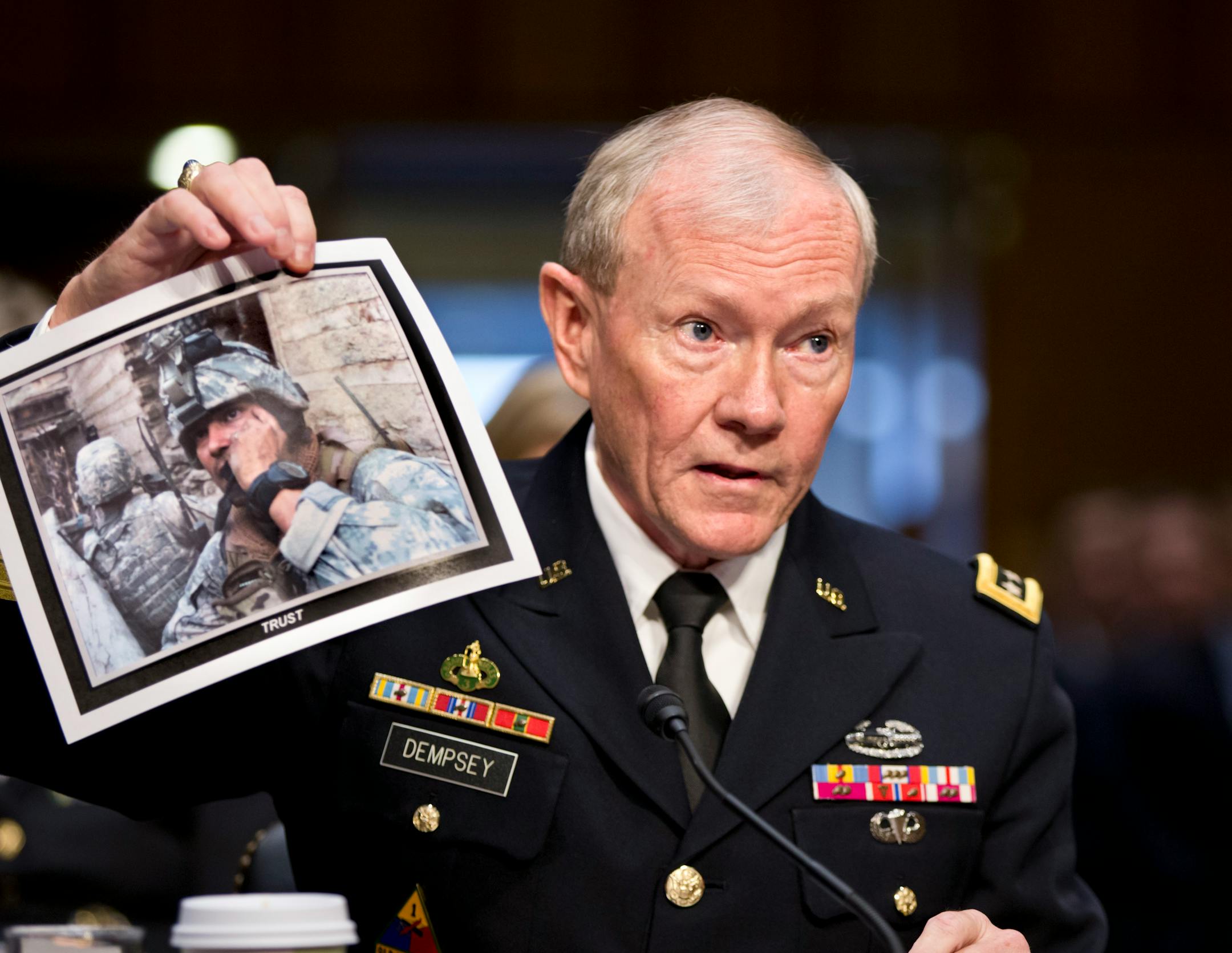 Gen. Martin Dempsey, chairman of the Joint Chiefs of Staff, holds up a photo of a deployed American soldier as he testifies before the Senate Armed Services Committee at his reappointment hearing, on Capitol Hill in Washington, Thursday, July 18, 2013. Dempsey said during congressional testimony Thursday that he has provided President Obama with options for the use of force in Syria.
