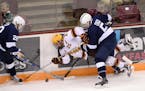 Minnesota Golden Gophers center Justin Kloos (25) fell to the ice while going after the puck being defended by Penn State Nittany Lions forward Alec M