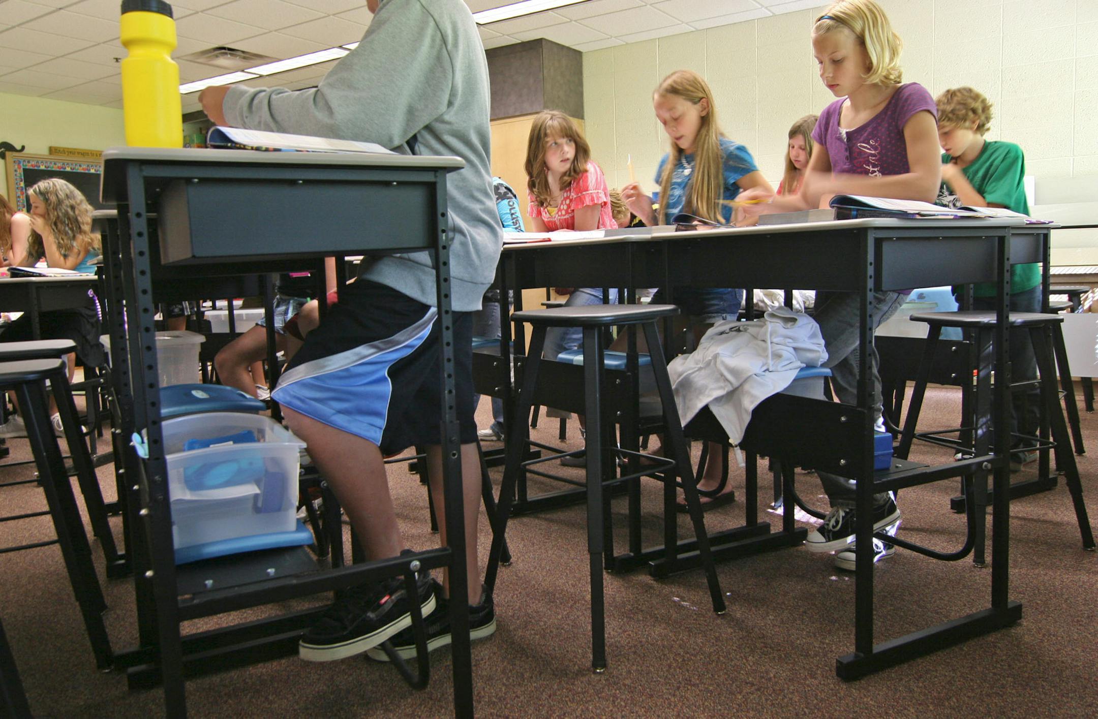 The stand-up desks developed by 6th grade teacher Abby Brown feature adjustable heights, a storage shelf for books and personal gear, a swinging foot rest, and heavy duty stool.