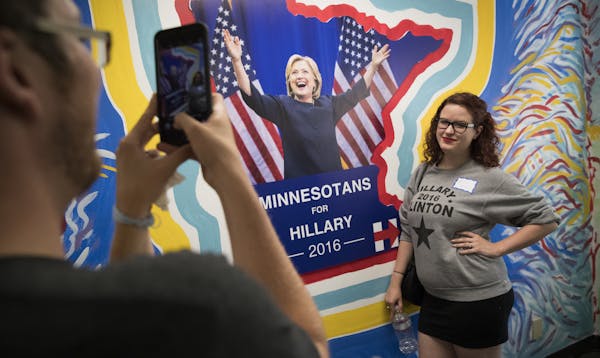 Hattie Cable posed next to a mural of Hillary Clinton as her husband Nic Cable took her picture in St. Paul on Wednesday.