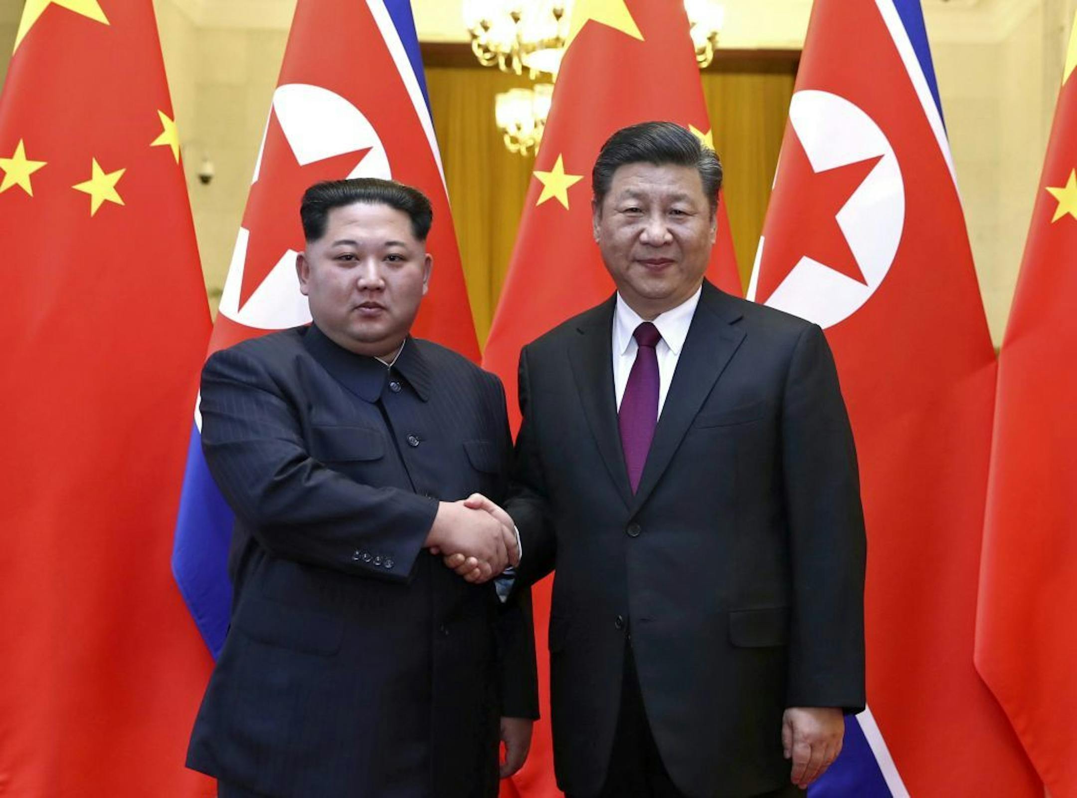 In this photo provided Wednesday, March 28, 2018, by China's Xinhua News Agency, North Korean leader Kim Jong Un, left, and Chinese President Xi Jinping shake hands in Beijing, China.