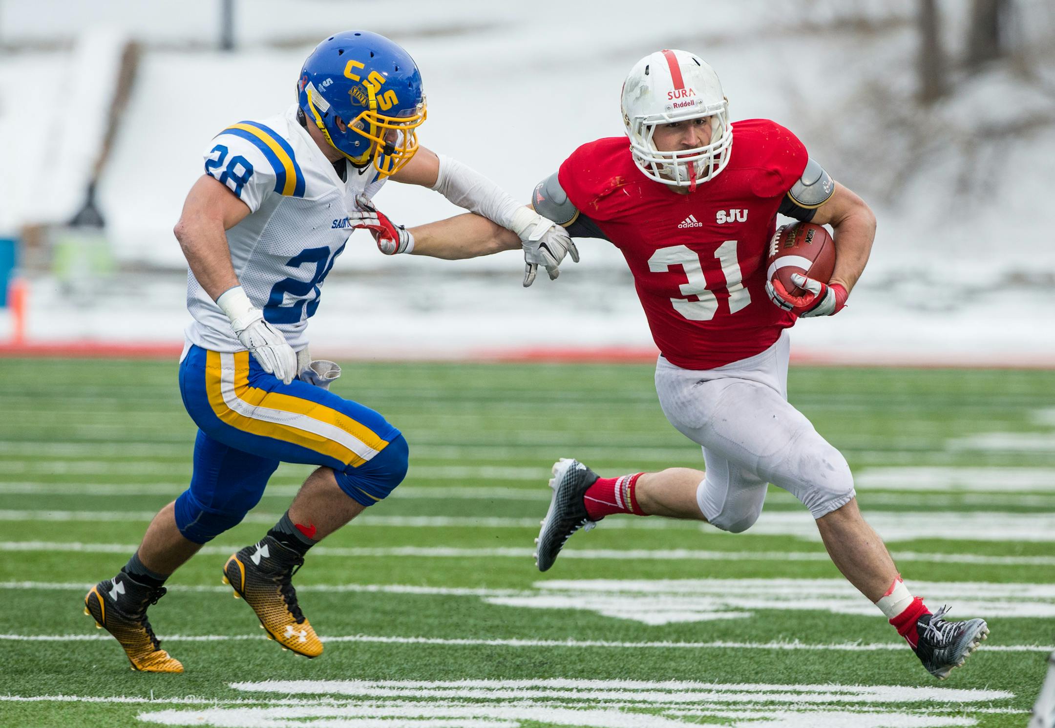 Photo by Brace Hemmelgarn/St. John's University
Sam Sura (31), who ran 28 times for 147 yards and three touchdowns for St. John's on Saturday in Collegeville, Minn., got around St. Scholastica defensive back Brady Fish (28).