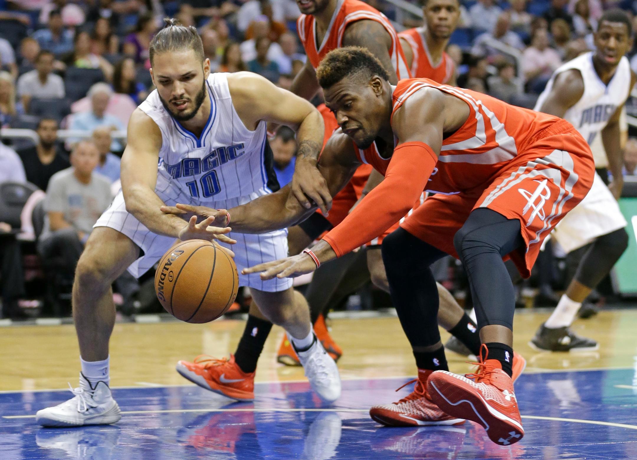 Orlando Magic's Evan Fournier (10), of France, battles Houston Rockets' Jeff Adrien, right, for a loose ball during the second half of an NBA preseason basketball game in Orlando, Fla., Wednesday, Oct. 22, 2014. Houston won 90-89. (AP Photo/John Raoux)