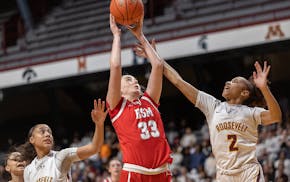 Benilde-St. Margaret’s Kate Kapsner goes up against the defense of Minneapolis Roosevelt’s Olivia Wren, left, and Jaida Walker.
