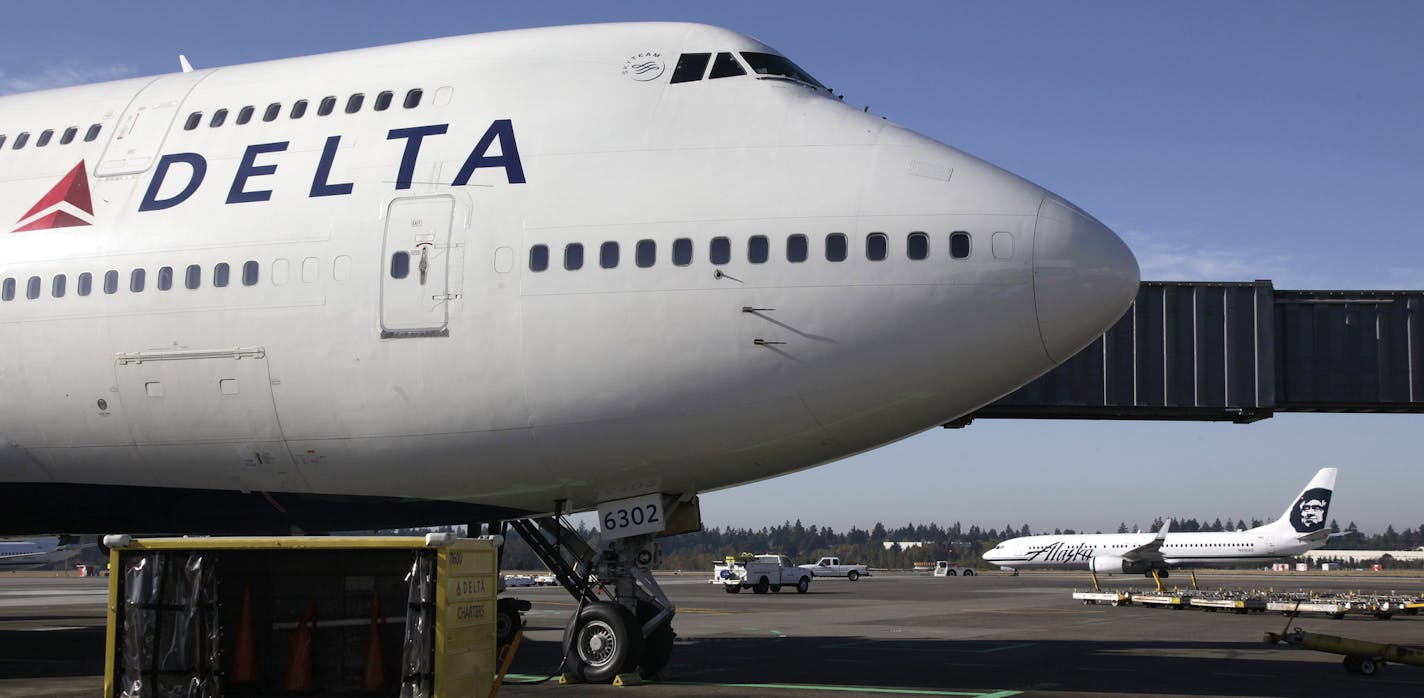 FILE - In this Oct. 8, 2012 file photo, a Delta Air Lines airplane is parked at Seattle-Tacoma International Airport in Seattle.