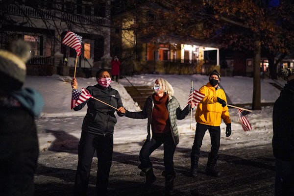 Deb Pleasants, Linda Ehlers and Carl Michaud waved their flags and danced at an inaugural  celebration street party Wednesday in St. Paul.