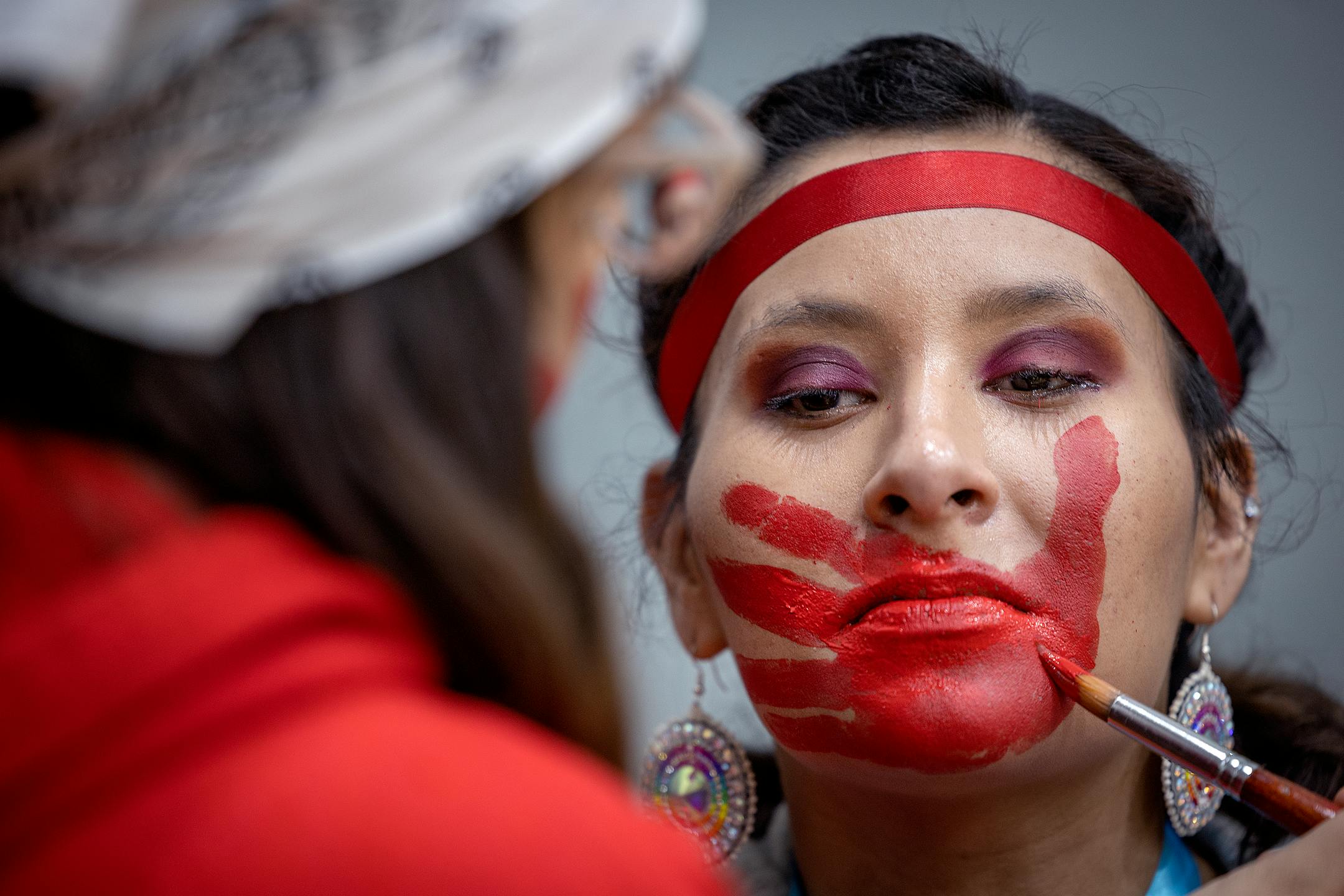 Alejandra Esquivel had a hand painted on her face by Jocelyn Martin on Tuesday, during the annual Missing and Murdered Indigenous Women's rally and march at the East Phillips Park Cultural &amp; Community Center, in Minneapolis.