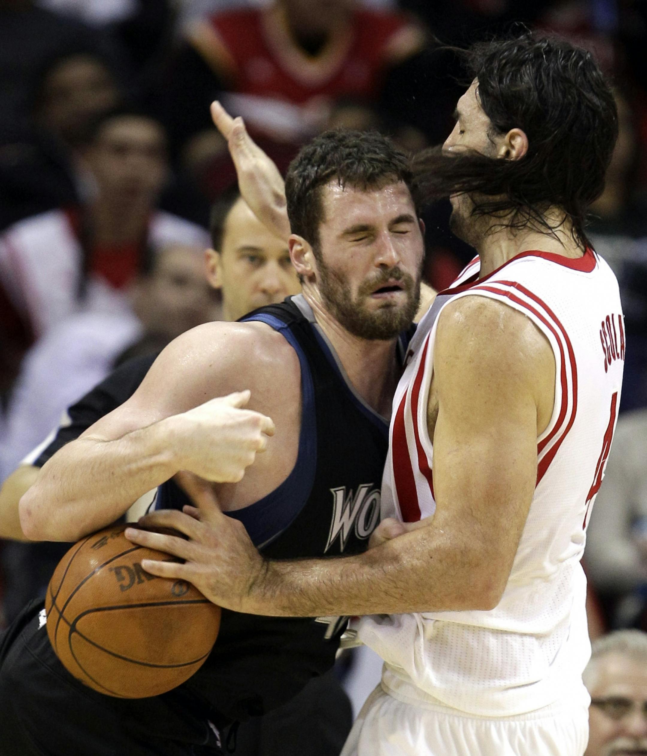 Minnesota Timberwolves' Kevin Love, left, charges into Houston Rockets' Luis Scola, right, of Argentina, during the third quarter of an NBA basketball game on Friday, Feb. 17, 2012, in Houston.