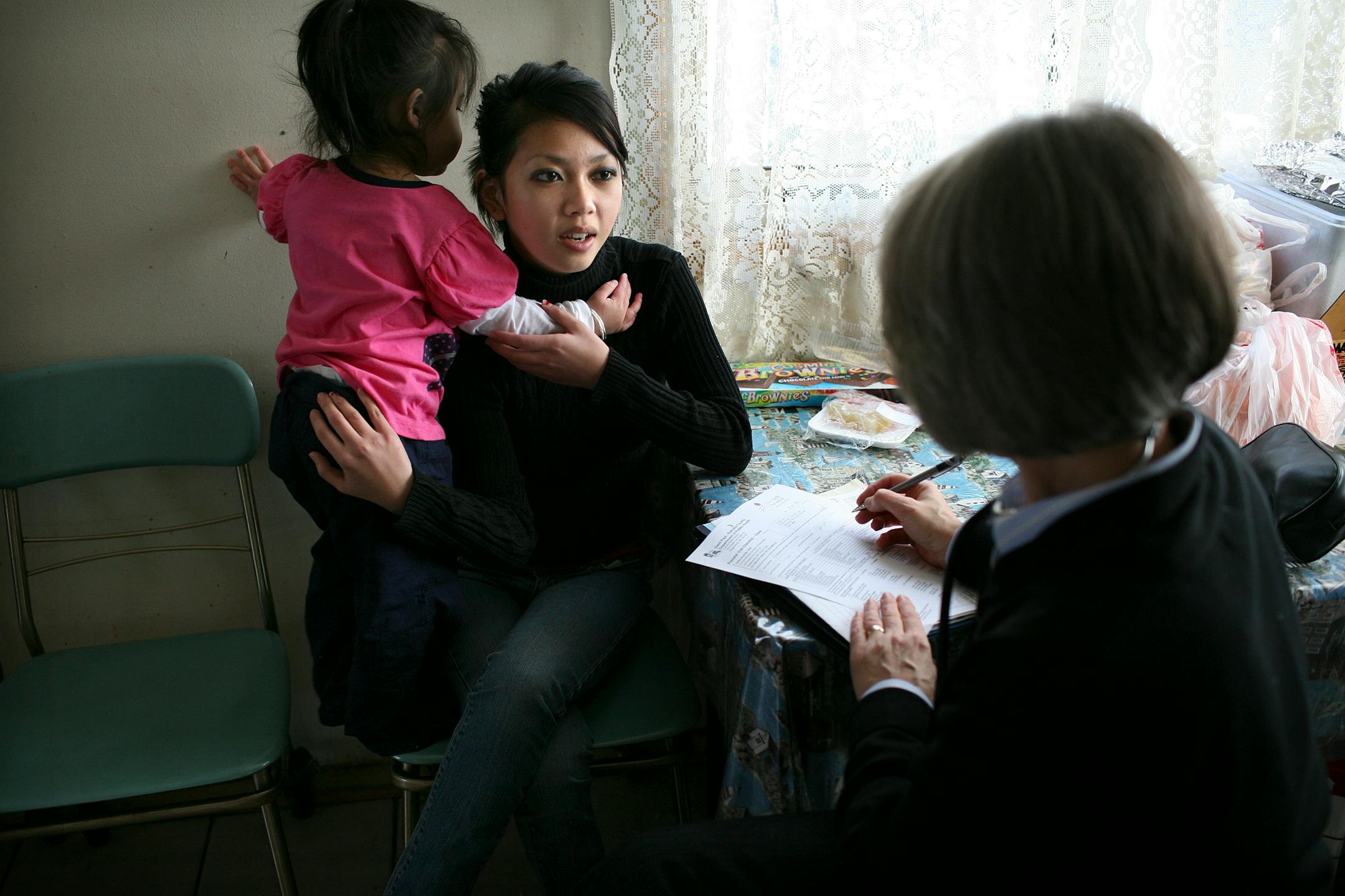 Cee Lor, center, of St. Paul is among the first Ramsey County mothers-to-be to take part in the Nurse-Family Partnership, designed to improve infant health and development and to help their parents succeed. Nurse Deb Avenido met with Lor at her parents' house, where the 17-year-old lives. Lor was holding her niece Calista Her.