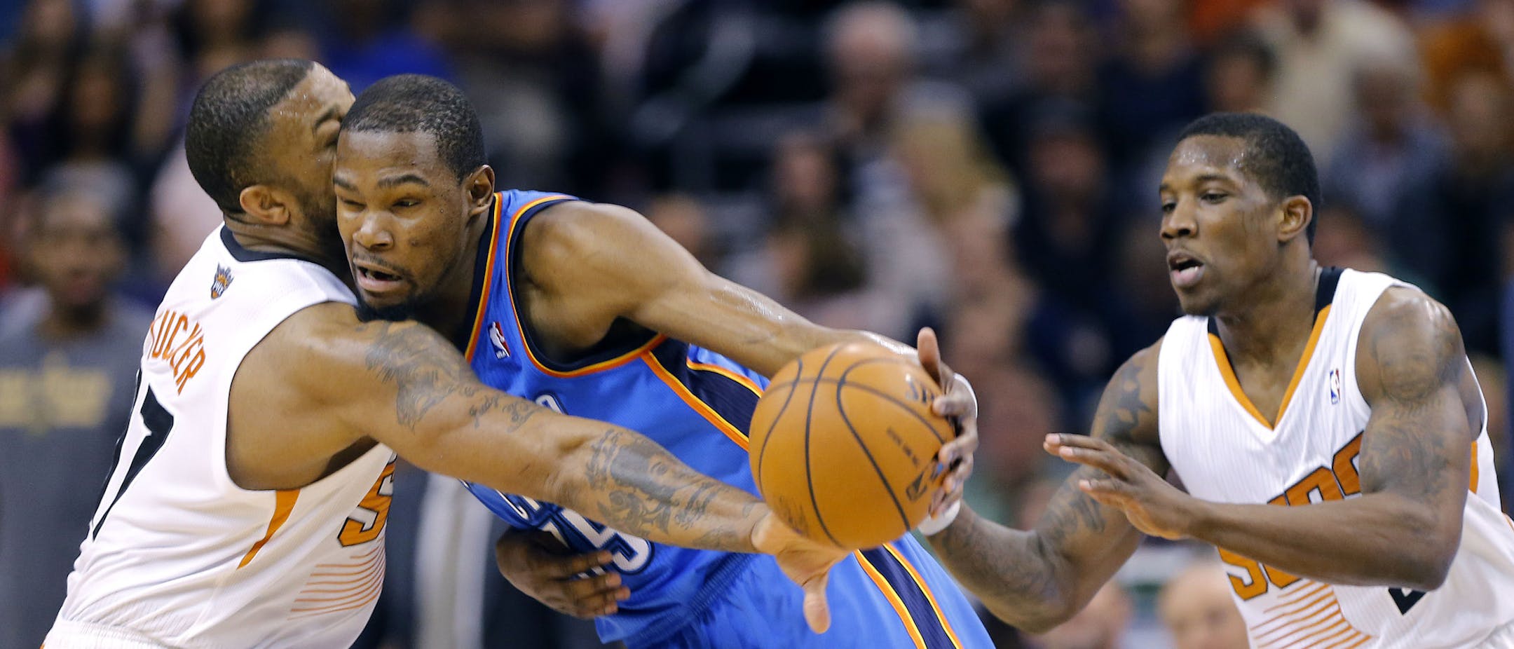 Oklahoma City Thunder forward Kevin Durant, center, collides with Phoenix Suns forward P.J. Tucker (17) during the first half of an NBA basketball game as Suns' Eric Bledsoe watches on Sunday, April 6, 2014, in Phoenix. The Suns won 122-115. (AP Photo/Matt York)