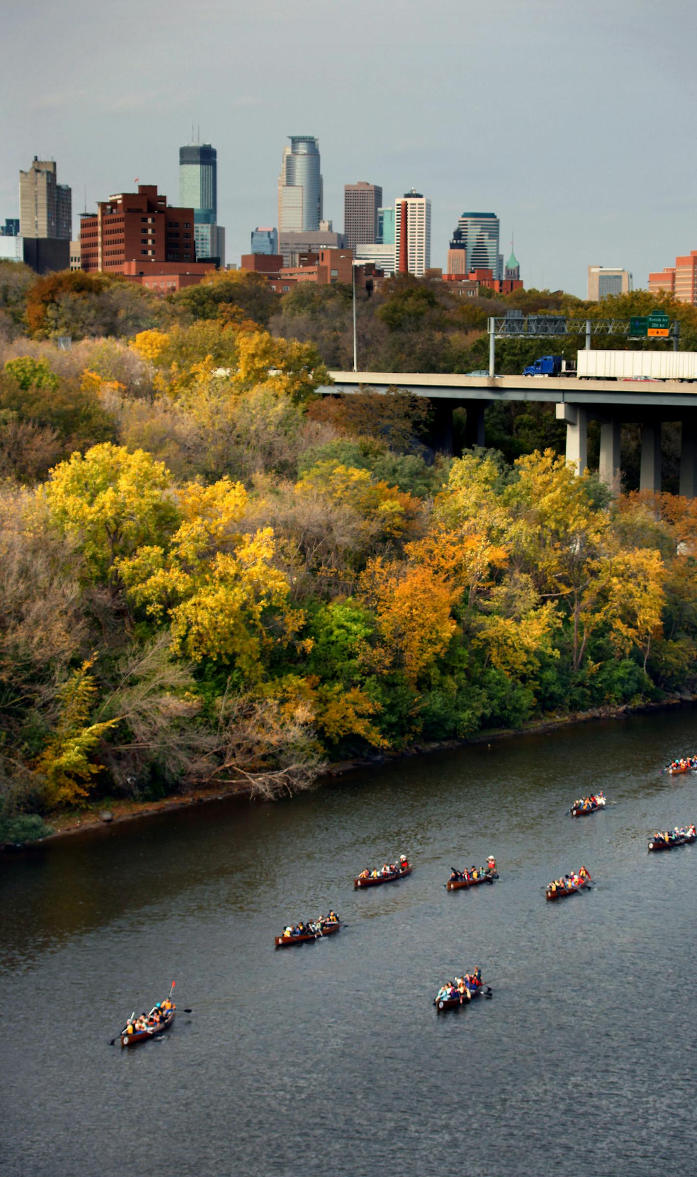 BRIAN PETERSON &#x2022; brianp@startribune.com Minneapolis, MN 10/20/09 ] Nine of the sixteen 24 foot voyager canoes filled with Minneapolis middle school children, paddle down the Mississippi River near the I-94 Bridge last week. The trips, sponsored by Wilderness Inquiry and the National Parks Service, hope to get more children exposed to this wonderful outdoor resource right here in the heart of the city as it runs through both Minneapolis and St. Paul.