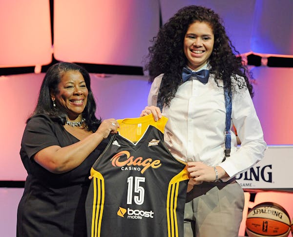Minnesota's Amanda Zahui B., right, holds up a Tulsa Shock jersey with WNBA president Laurel J. Richie after the Shock selected Zahui B. as the No. 2 