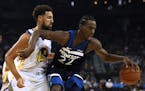 The Timberwolves' Andrew Wiggins, right, keeps the ball from Golden State Warriors' Klay Thompson
