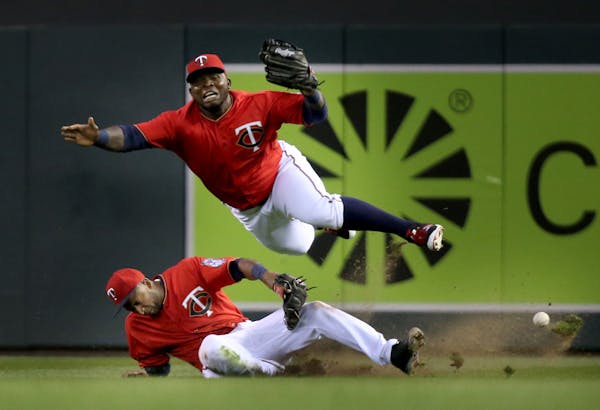 Minnesota Twins right fielder Miguel Sano, top, and second baseman Eduardo Nunez collide in right field while chasing a fly ball hit by the Los Angele