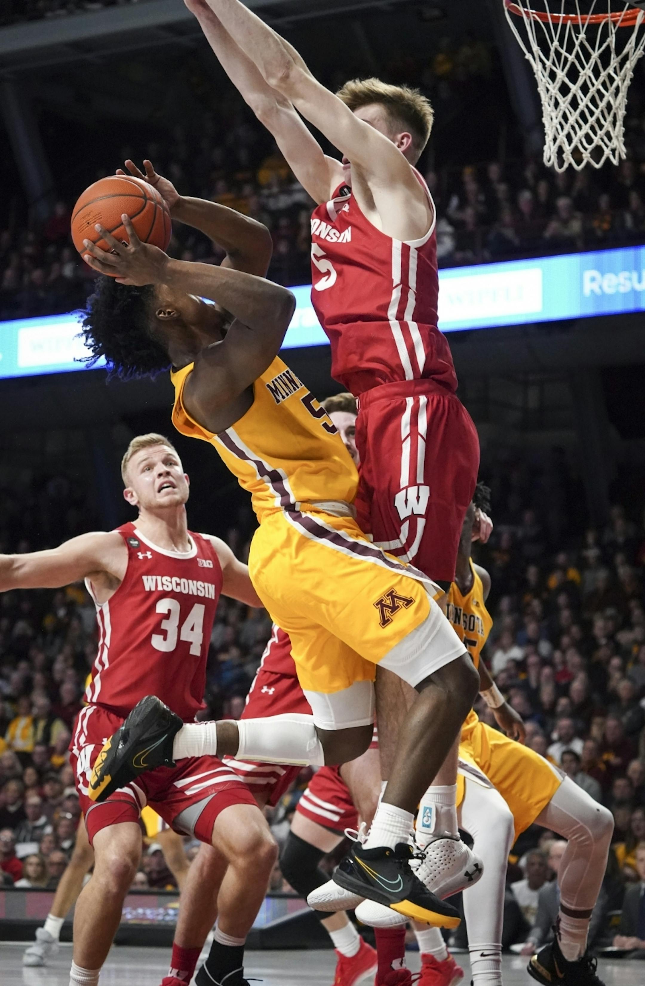 Minnesota Gophers guard Marcus Carr (5) was blocked by Wisconsin Badgers forward Tyler Wahl (5) during a shot attempt in the first half. A foul was called on Wisconsin.