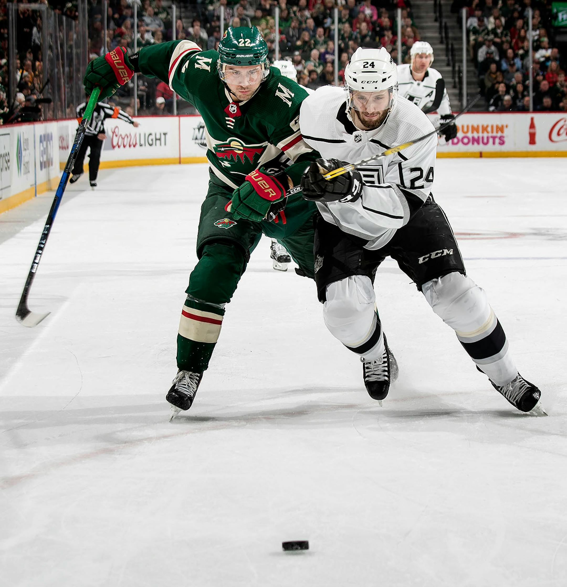 Nino Niederreiter (22) and Derek Forbort (24) chased the puck in the first period.