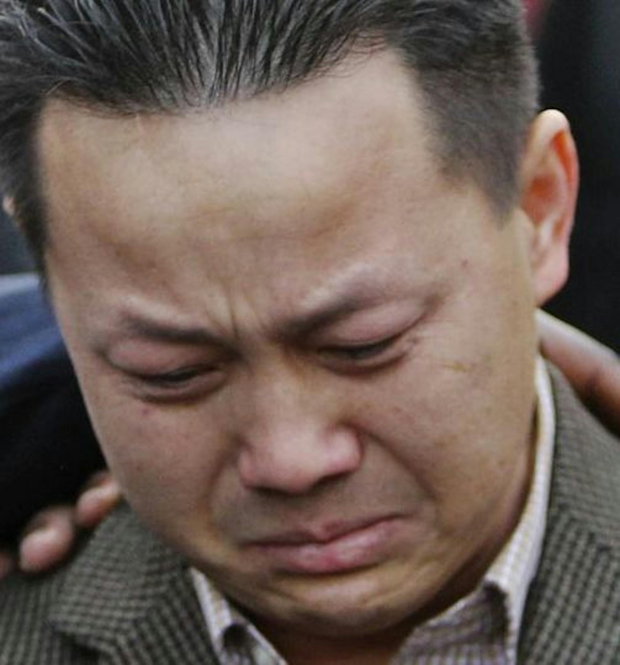 Kao Xiong, the father of two-year old shooting victim Neegnco Xiong, is comforted by Rev. Harding Smith of the Spiritual Church of God, left, and peace activist K.G. Wilson, right, as Xiong fought back tears while remembering his son during a vigil near the family's Cedar-Riverside area residence Saturday, Dec. 8, 2012, in Minneapolis, MN.] (DAVID JOLES/STARTRIBUNE) djoles@startribune.com) A vigil was held for two-year old shooting victim Neegnco Xiong near the family's Cedar-Riverside area resi