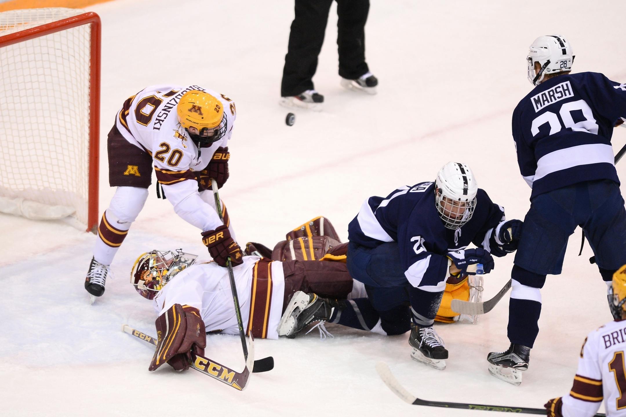 A goal by Penn State was called back due to interference as Penn State Nittany Lions forward Ricky DeRosa (21) was slow to get off of Minnesota Golden Gophers goalie Eric Schierhorn (37) after a scoring attempt in the first period.