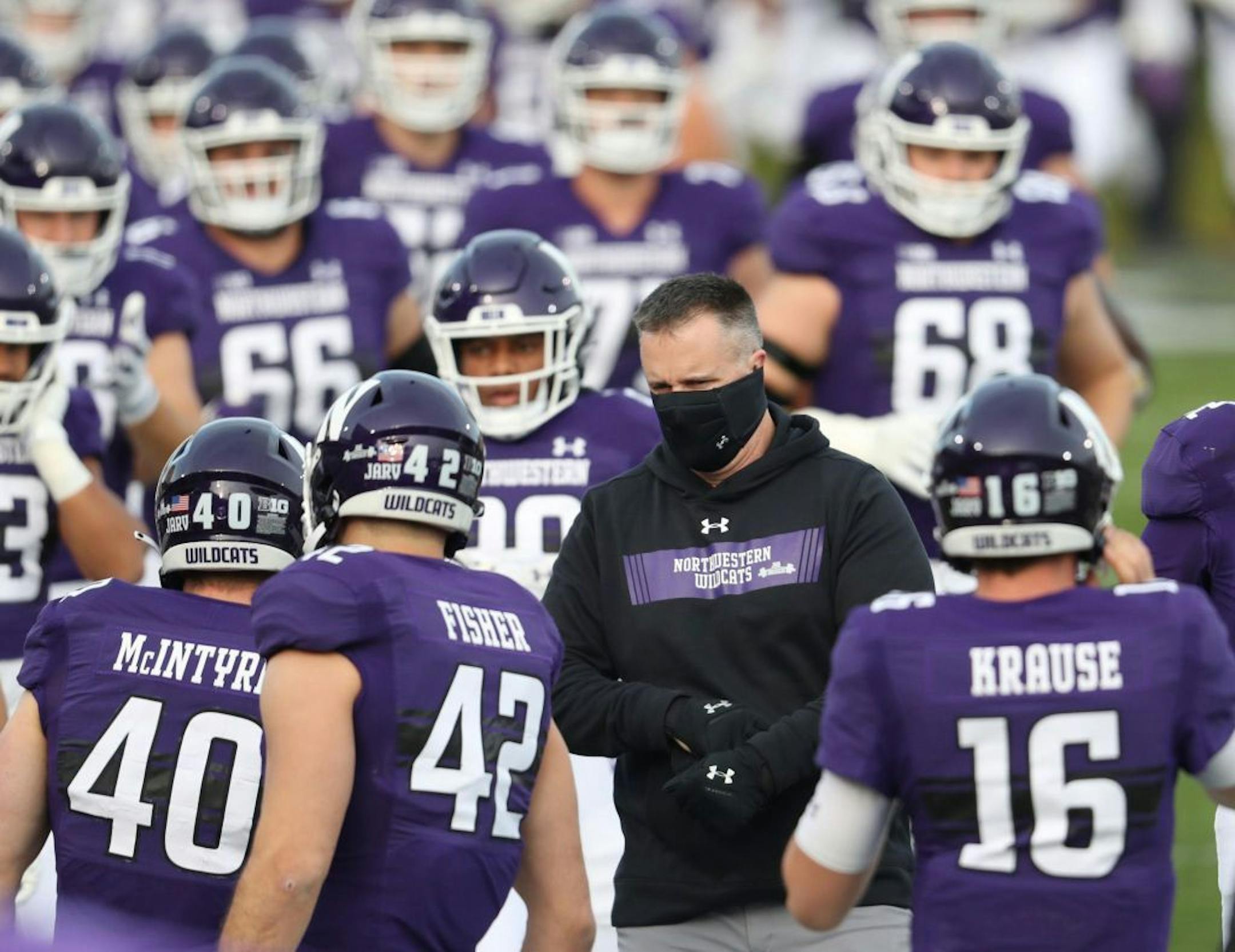 Northwestern coach Pat Fitzgerald, center right, wearing a face mask, enters the field with his team for a game against Wisconsin on Saturday, Nov. 21, 2020 at Ryan Field in Evanston, Illinois. Northwestern won, 17-7.