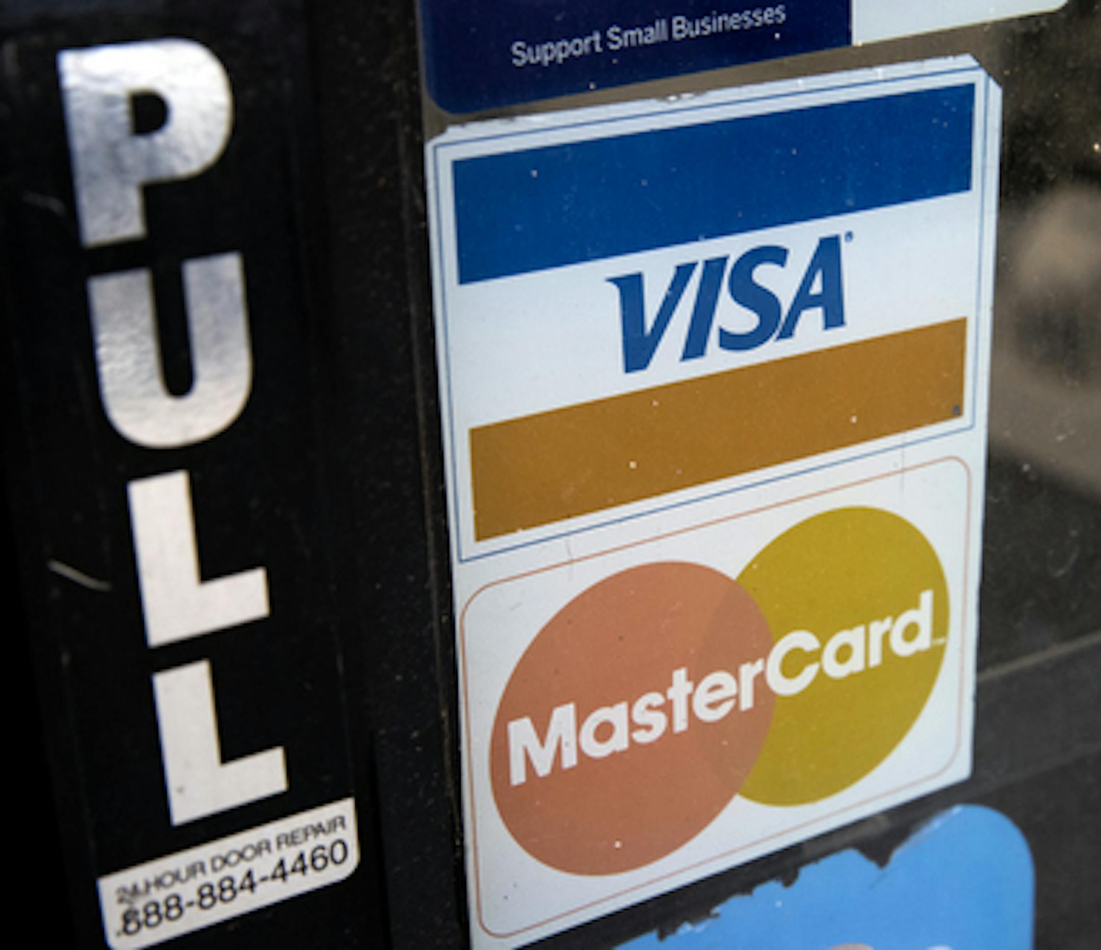 This Nov. 29, 2018, photo shows credit card logos posted on a store's door in Philadelphia. On Tuesday, Jan. 8, 2019, the Federal Reserve releases its November report on consumer borrowing (AP Photo/Matt Rourke)