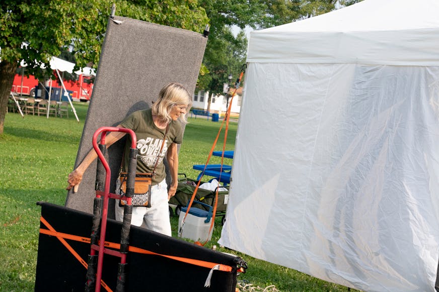 Artist Annette Mattingly, 70, of Ely, Minn. sets up a booth for Morning Glory Creations pressed flower art for the 45th annual Blueberry Arts Festival weeklong event that draws thousands of attendees after a flash flood Thursday, July 24, 2025 at Whiteside Park in Ely, Minn. "We are resilient," Mattingly said about the festival continuing on despite the weather event.