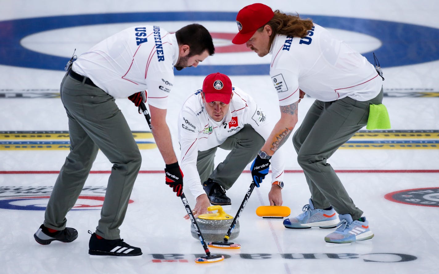 United States skip John Shuster, center, makes a shot as second Matt Hamilton, right, and lead John Landsteiner sweep against Denmark at the men's World Curling Championships Thursday, April 8, 2021 in Calgary