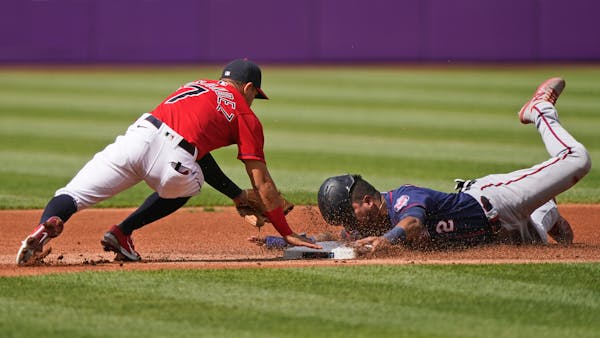 Minnesota Twins' Luis Arraez, right, tries to steal to second base as Cleveland Indians' Cesar Hernandez, left, makes the tag in the first inning of a